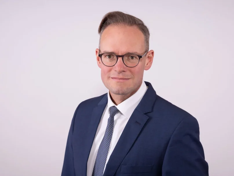 Ein Mann trägt einen Anzug und eine Krawatte für ein Pressefoto